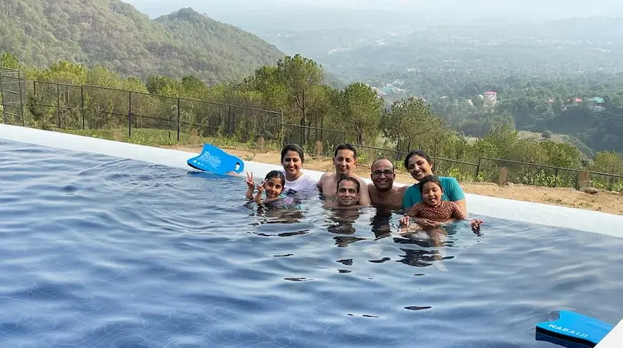 family enjoying swimming in a resort in dharamshala with a pool