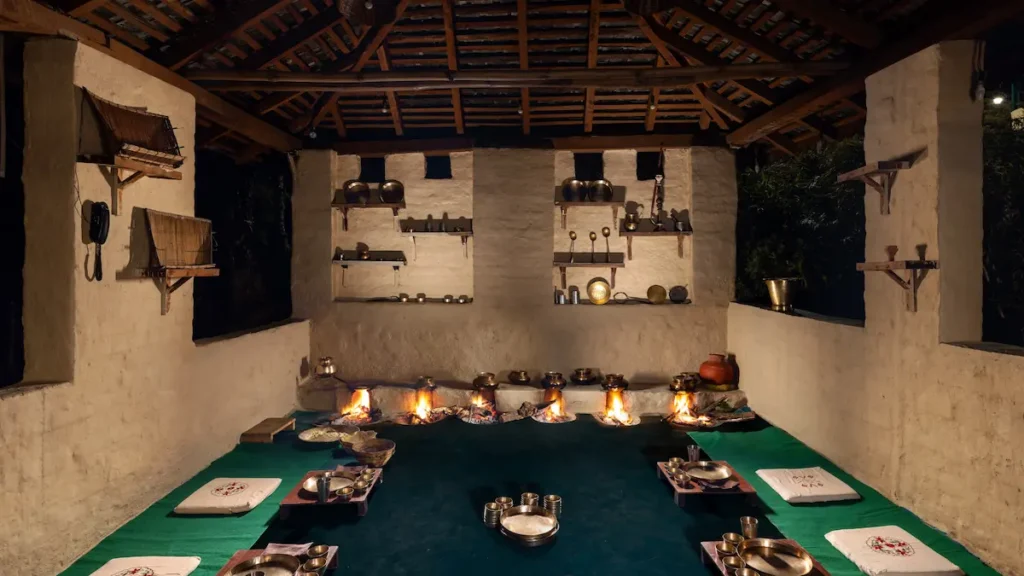 A view of rustic Himachali kitchen at Rakkh Resort with traditional wood-fired stoves and brass utensils.
