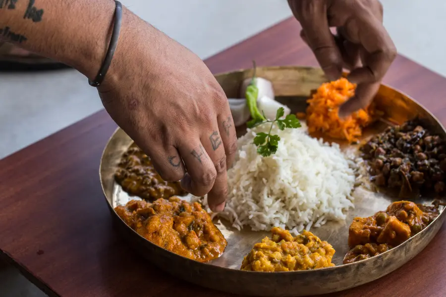 View of chef plating authentic Himachali thali with local delicacies at Rakkh Resort.