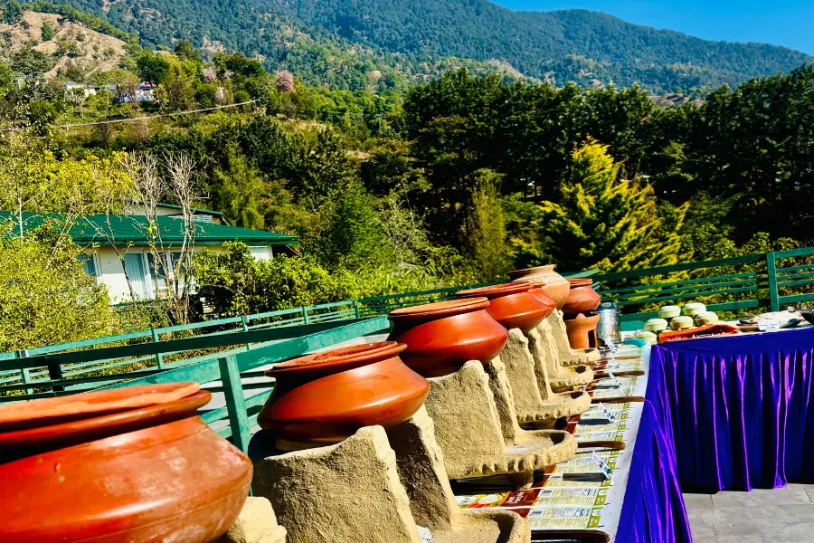 View of traditional Himachali clay pot setup at Rakkh Resort with a stunning mountain backdrop.