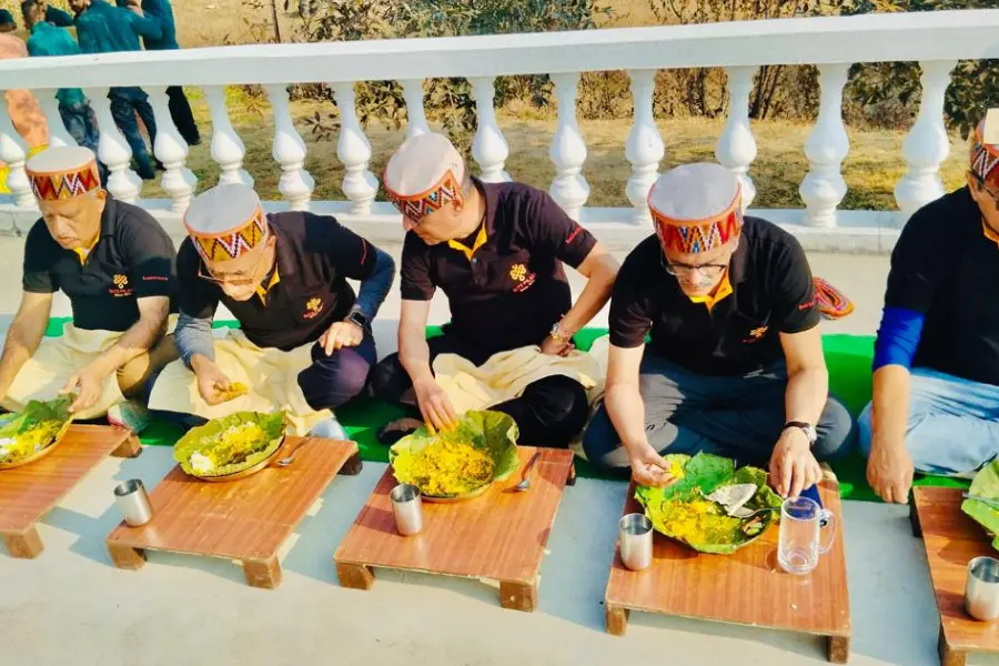 Guests enjoying local food together at a resort in Himachal Pradesh with a calm mountain view in the background
