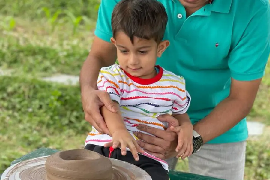 View of kid learning pottery at Rakkh Resorts.